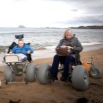 People in wheelchairs on beach