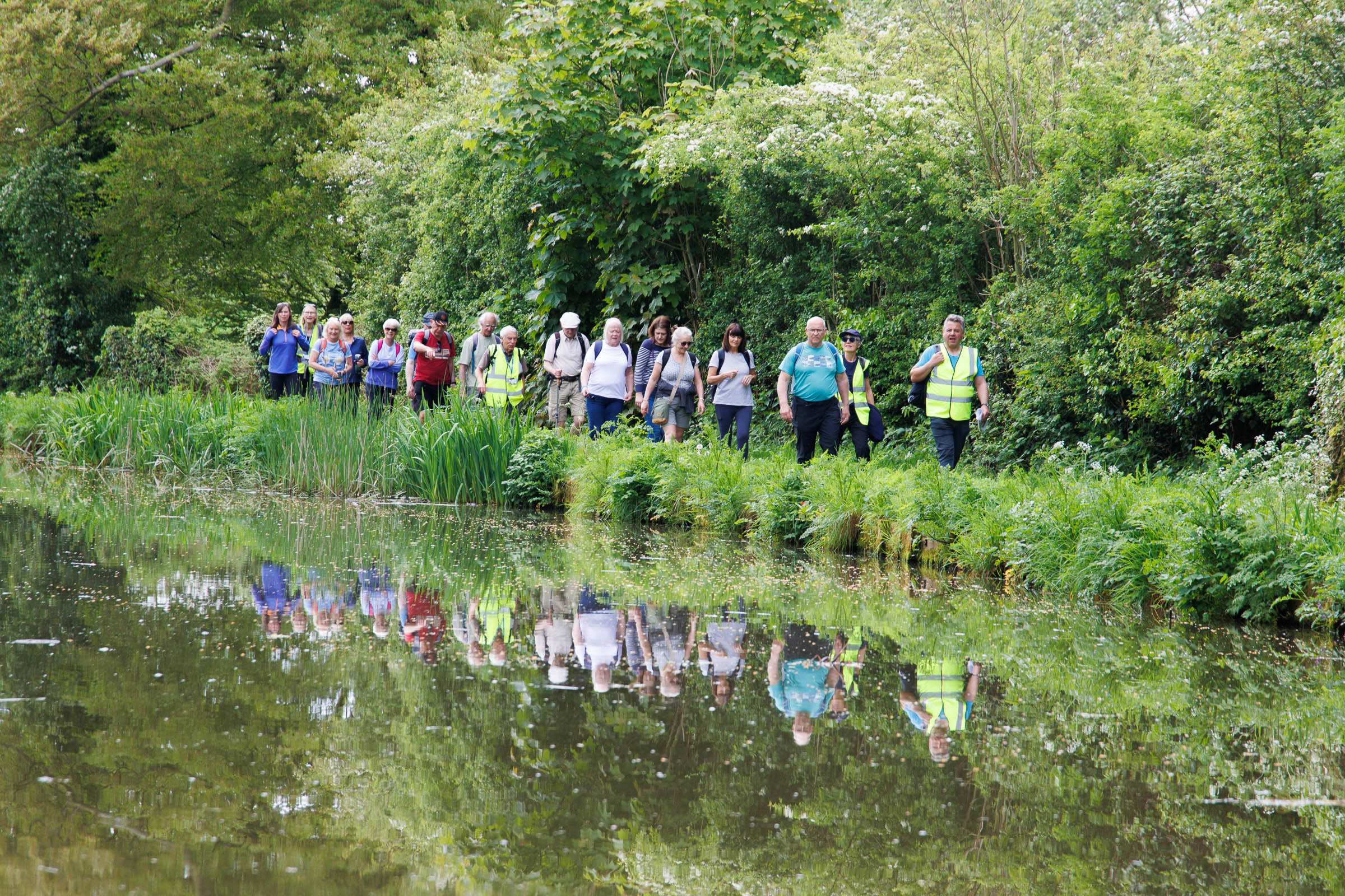 Group of people walking in a line by the edge of the River Wyre