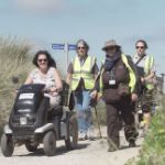 People walking alongside tramper