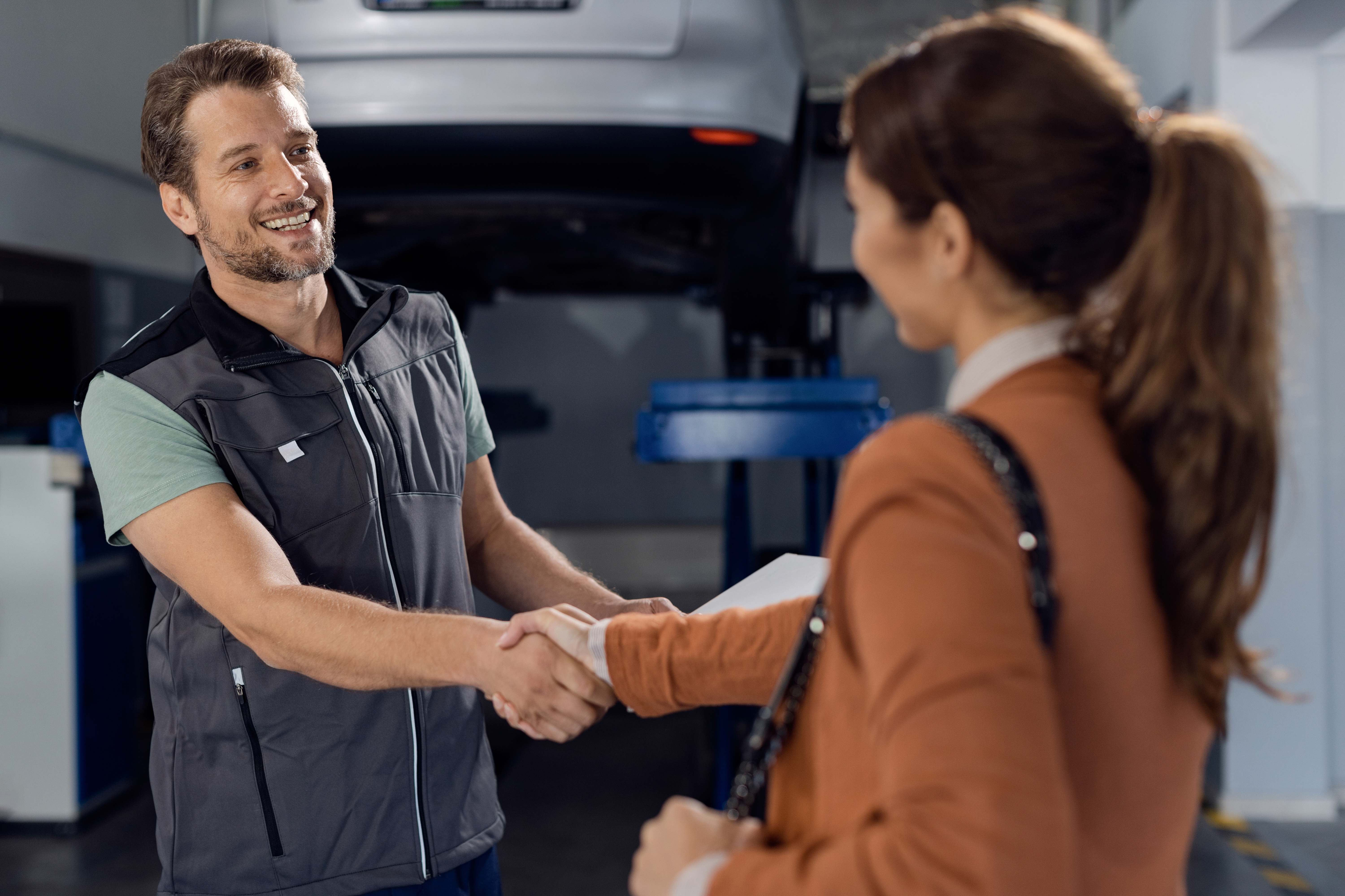 a mechanic shaking hands with a woman